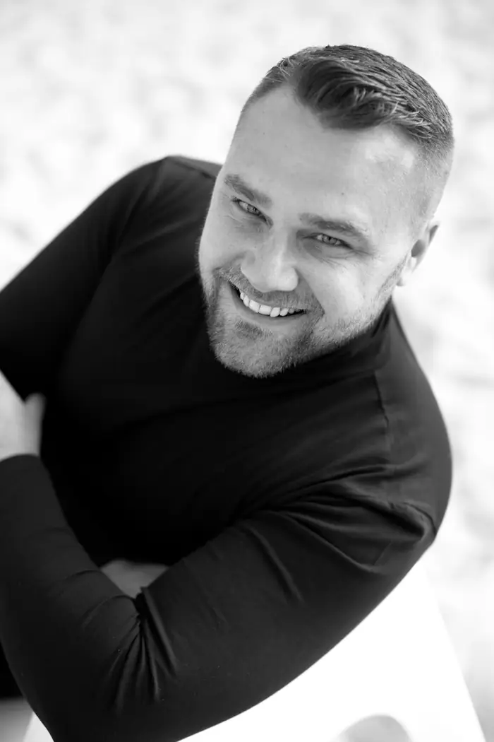 Pavel Filandr se usmívá, černobílý portrét ze svrchního pohledu